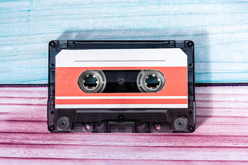 Top view of a music cassette on a background of colored wood.