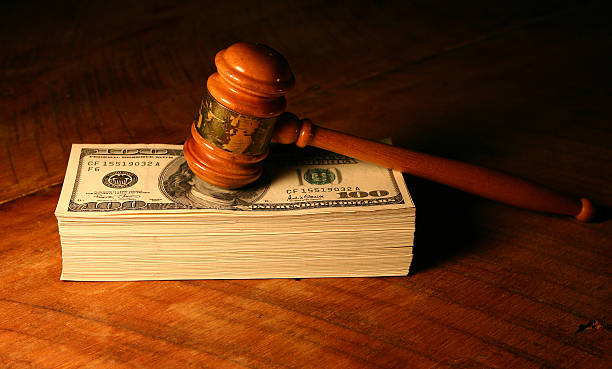 Settle out of Court Used gavel on a stack of money. human settlement stock pictures, royalty-free photos & images