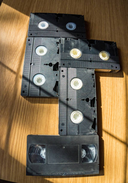 istock Vintage videotapes on a wooden table., on beige background. 1726344537