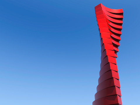 Concept for reaching for the sky/sky is the limit. Red abstract skyscraper against blue sky. Lots of space for copy.