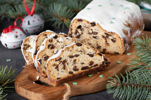 Christmas German Stollen with dry fruits and nuts on wooden board. Traditional treats