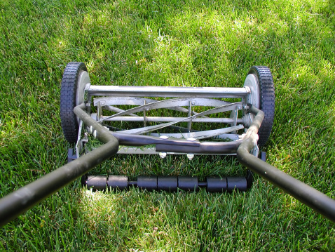 A push lawnmower cutting the grass.