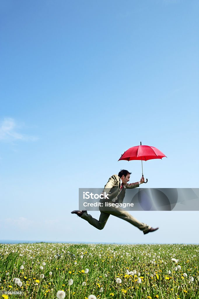 Empresário pulando em um Prado - Foto de stock de Guarda-chuva royalty-free