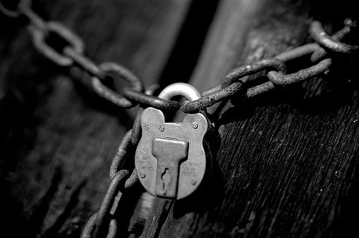 A lock suspended by two chains.