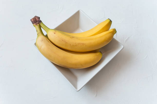 istock Two Ripe yellow bananas on white plate. white background. Top view 1726370209