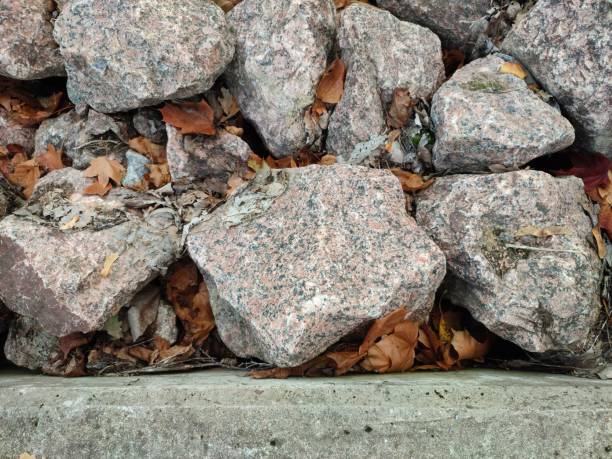 concrete curb and granite boulders in the fall. maple leaves