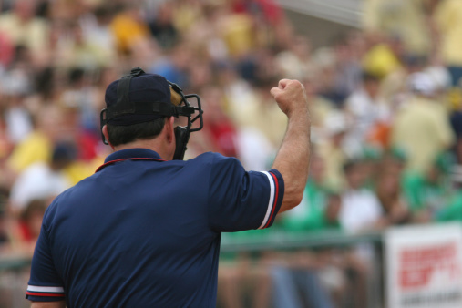 Home plate umpire brushing off home plate during a baseball game