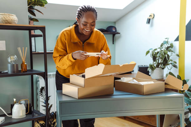 istock Young African-American holding cardboard boxes and using smart phone 1726375488