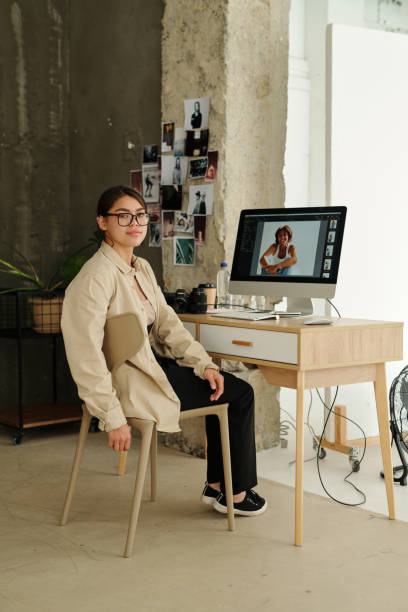 istock Young professional photographer looking at camera while sitting by workplace 1726379560