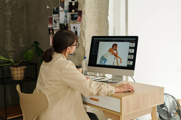 istock Young female photographer sitting in front of computer screen 1726380323