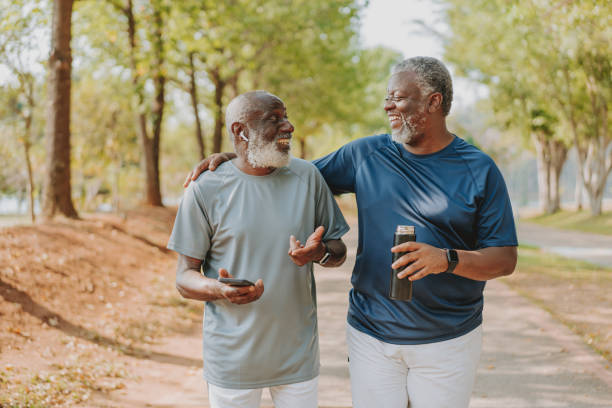 istock Two black senior friends walking together in public park 1726382005