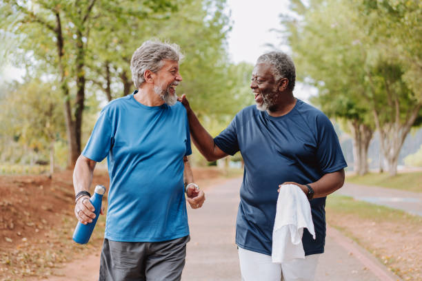 istock Two elderly friends walking together in public park 1726383136