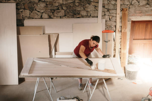 mujer carpintera que elabora una puerta de granero - home addition barn house restoring fotografías e imágenes de stock