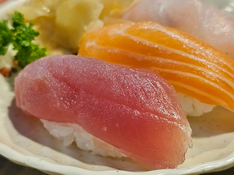 One tuna sushi, one salmon sushi and one white fish sushi. Japanese food