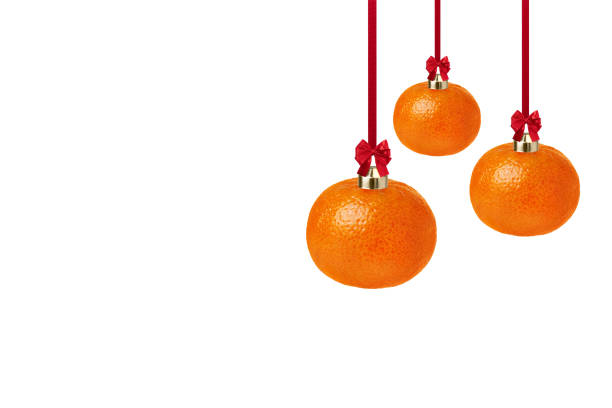 Tangerine as a Christmas ornament isolated on white background with copy space. Creative Christmas greeting card.