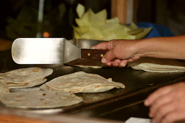 A close-up of golden-brown pancakes on the griddle