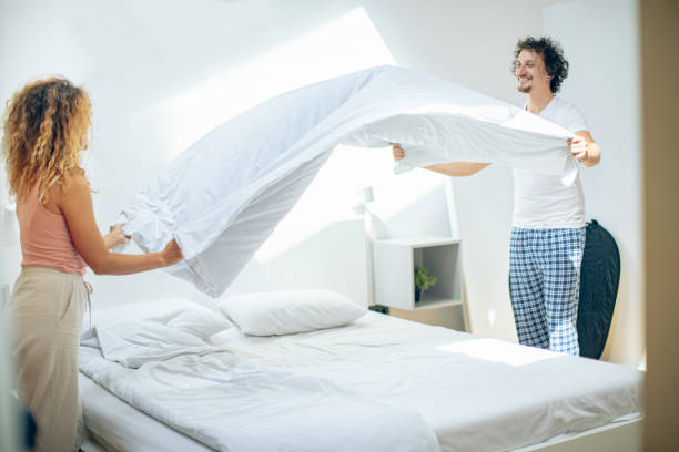 istock Young beautiful couple smiling making their bed at home 1726388927