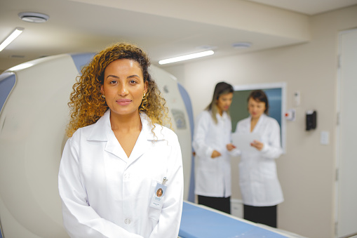 portrait of doctor in front of magnetic resonance imaging machine