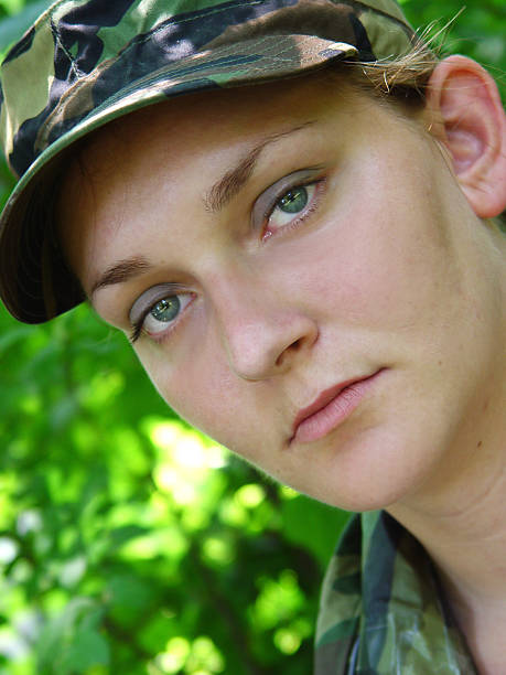 Girl near the brick wall in military style.