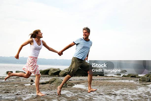 Foto de Casal Correndo Na Praia e mais fotos de stock de Adulto - Adulto, Alegria, Amor