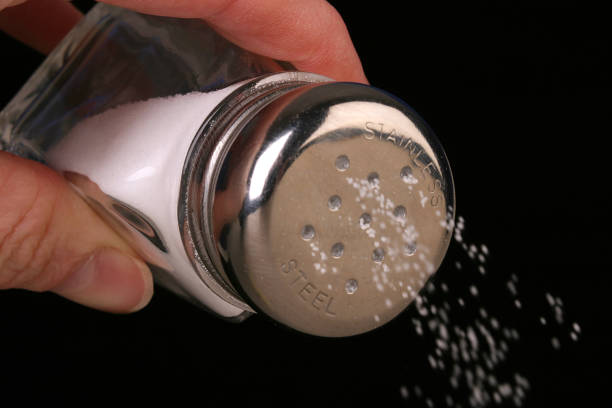 istock Hand holding a salt shaker pours salt granules 172640330