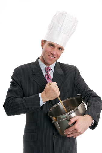 Businessman in chef's hat cooks up a deal against white background