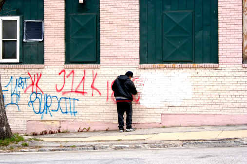 Man removing graffiti from building