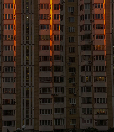 The facade of a modern apartment building at night.