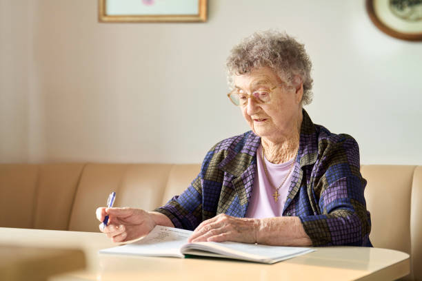 istock Senior woman working on a word search puzzle in her kitchen 1726426820