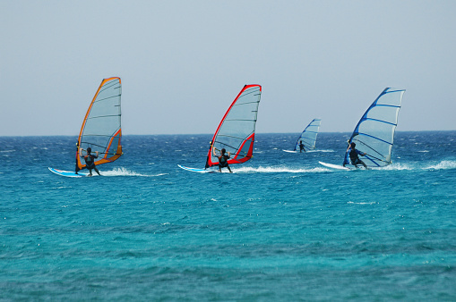 two windsurfer,blue sea,colourful sails