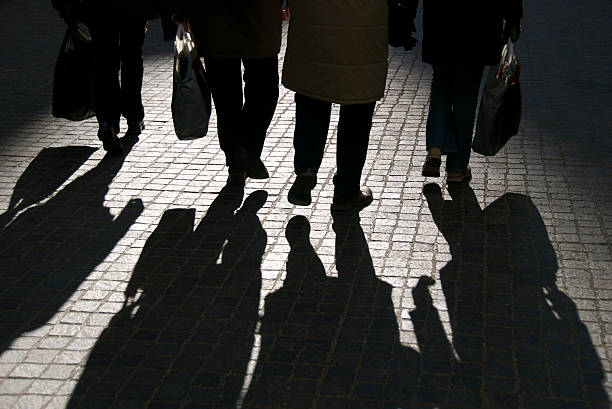 vier personen und schatten walk informiert - rush hour commuter shadow focus on shadow stock-fotos und bilder