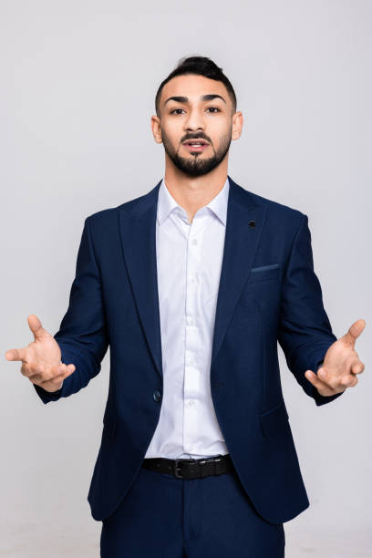 istock Young delighted turkish buisnessman standing on grey background in studio isolated looking at camera talking speaking having buisness fashion shooting process 1726445441