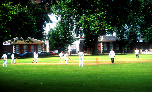 Playing cricket in the park, a real traditional British sport shot in Chelsea London England.