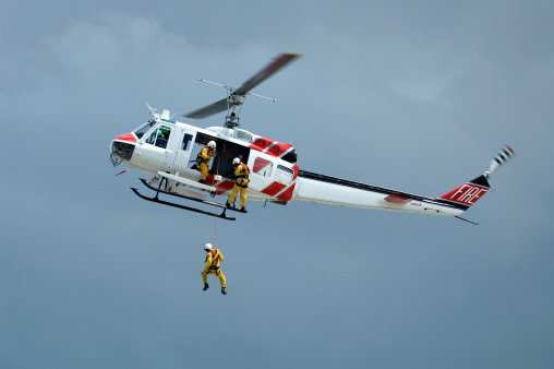 Third in a series of this helicopter rescue training exercise.  One of three people is in the process of being lowered in his harness.Others in this series: