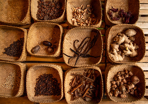 Woven bamboo baskets with variety dried spices with cinnamon, ginger and vanilla at Bali kitchen counter