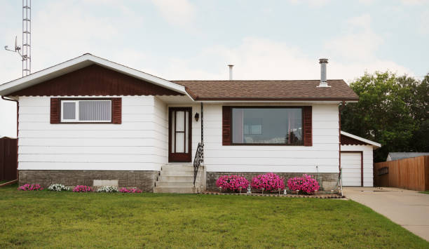 Front view of the facade of a bungalow style house with a yard and small garden in a quiet residential area