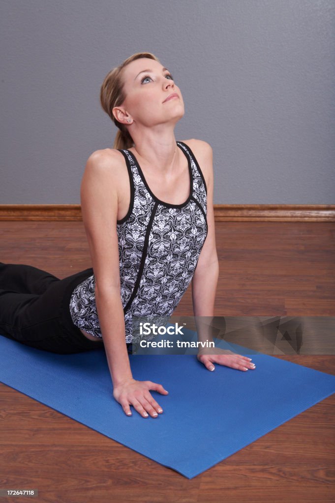 Yoga concentration - The Cobra Pose "A young woman holds a pose on her yoga mat. She is performing the Cobra Pose, the Bhujangasana. Shot with Canon 5D." Active Lifestyle Stock Photo