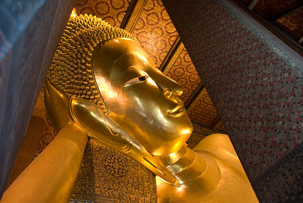 The monumental head and arm of the Reclining Buddha monument at Wat Pho, Bangkok in Thailand.  The Buddha was constructed between 1824 and 1851.
