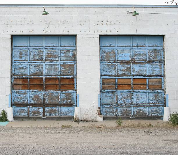 istock Two blue wooden garage doors with faded paint 172648485