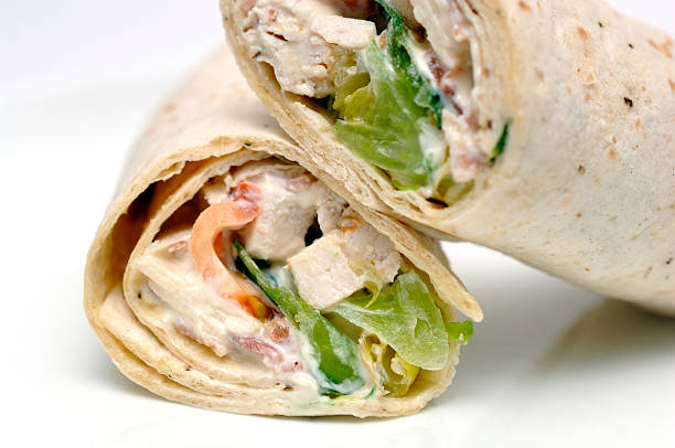 chicken caesar salad totilla wrap on a white plate