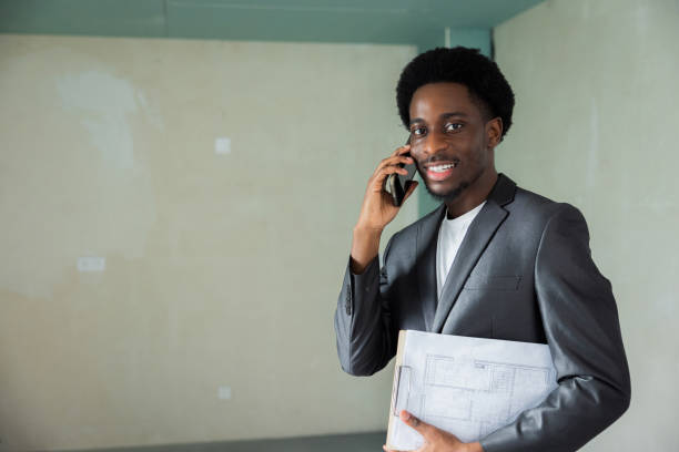 Handsome smiling serious concentrated buisnessman in house talking on phone solving problems.