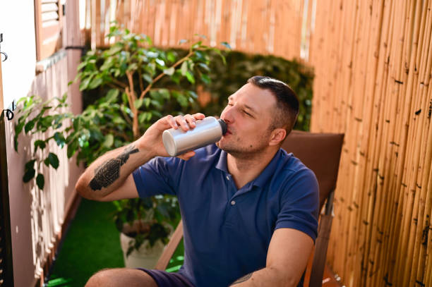 young man drinking fresh water from an aluminum bottle.