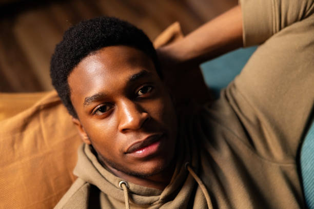 istock Handsome African American dark skinned reader, enjoying a good book on his phone and taking advantage of the comfort of his home 1726510549