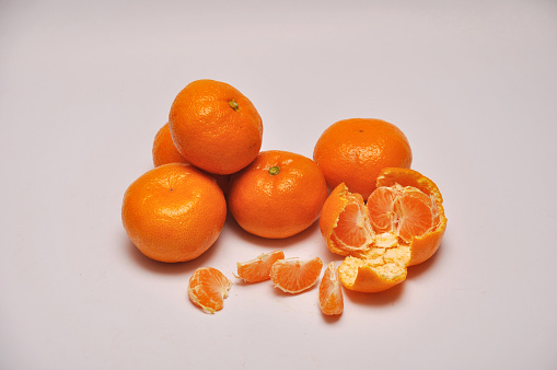 whole and sliced mandarins on a seamless background