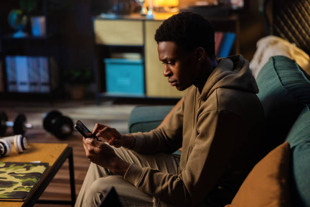 istock Happy elighted African American dark skinned freelancer or entrepreneur, using his phone to stay in touch with clients while working on projects on his laptop 1726514564
