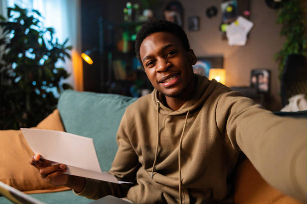 istock Delighted African American dark skinned academic researcher analyzing data and writing a research paper sitting in cozy living room 1726518431