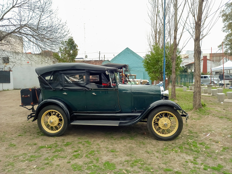 Lanús, Argentina - Sept 23, 2023: Side view of an old green Ford Model A Fordor phaeton on the lawn in a park. Classic car show