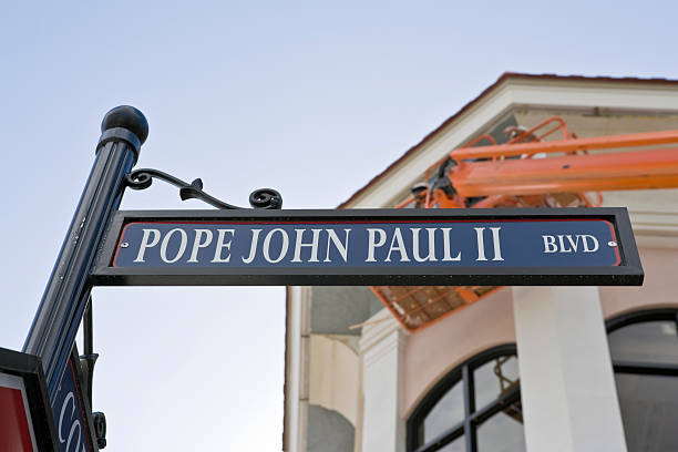 Pope John Street sign honoring the late Pope John Paul II. Building and crane in background with workers. pope john paul ii stock pictures, royalty-free photos & images