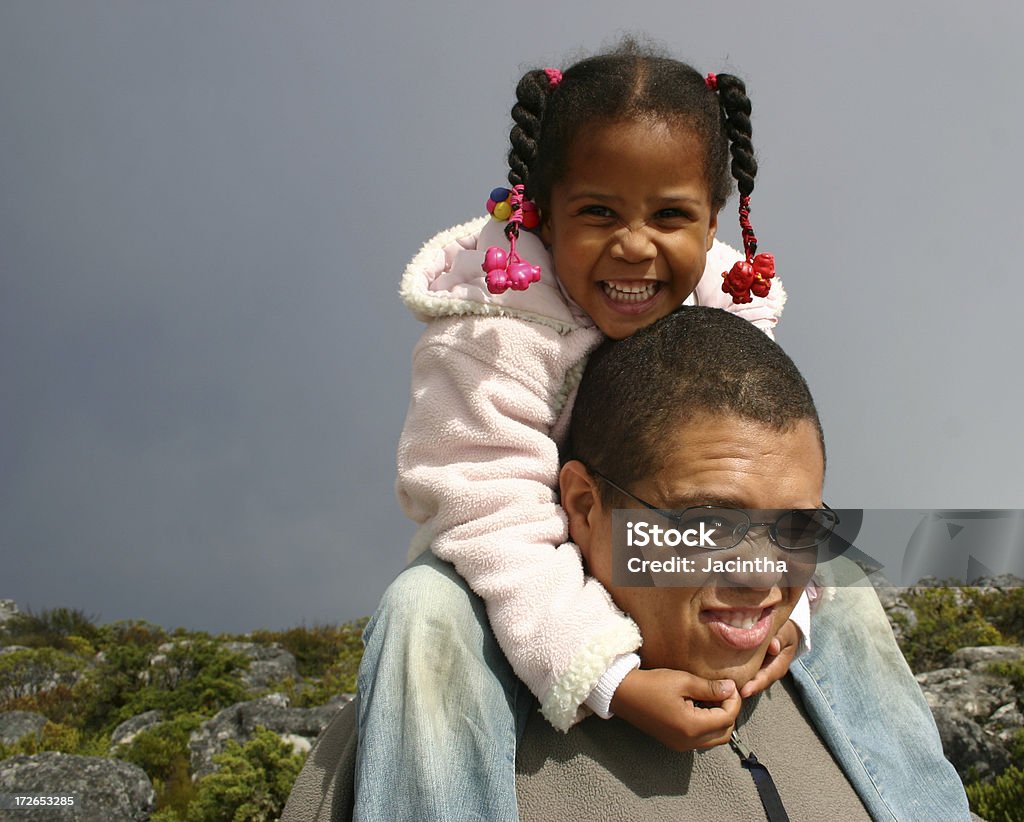 On daddies shoulder Little African girl sitting on her daddies shoulders Adult Stock Photo