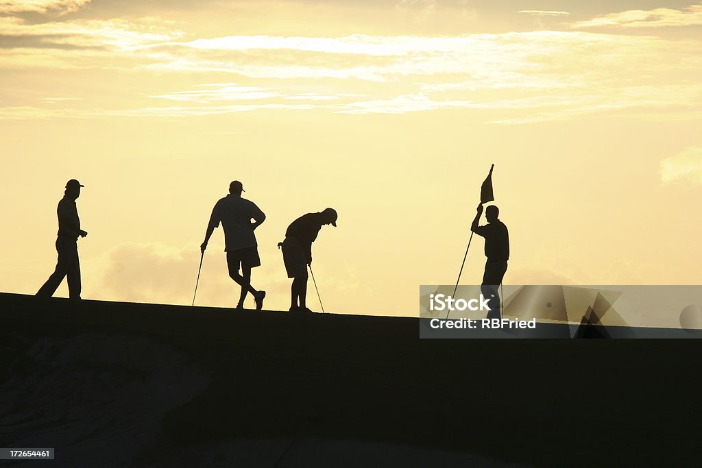 Golfers at Sunset 2 golfing at sunset Golf Stock Photo